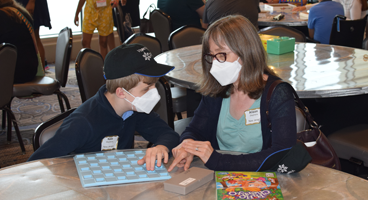 Mother and son play a game together during a game night at convention.