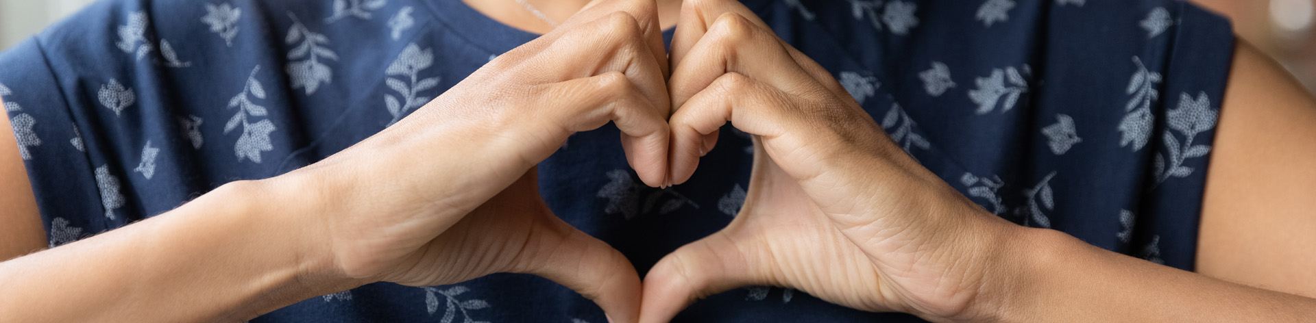 Hands form the shape of a heart.